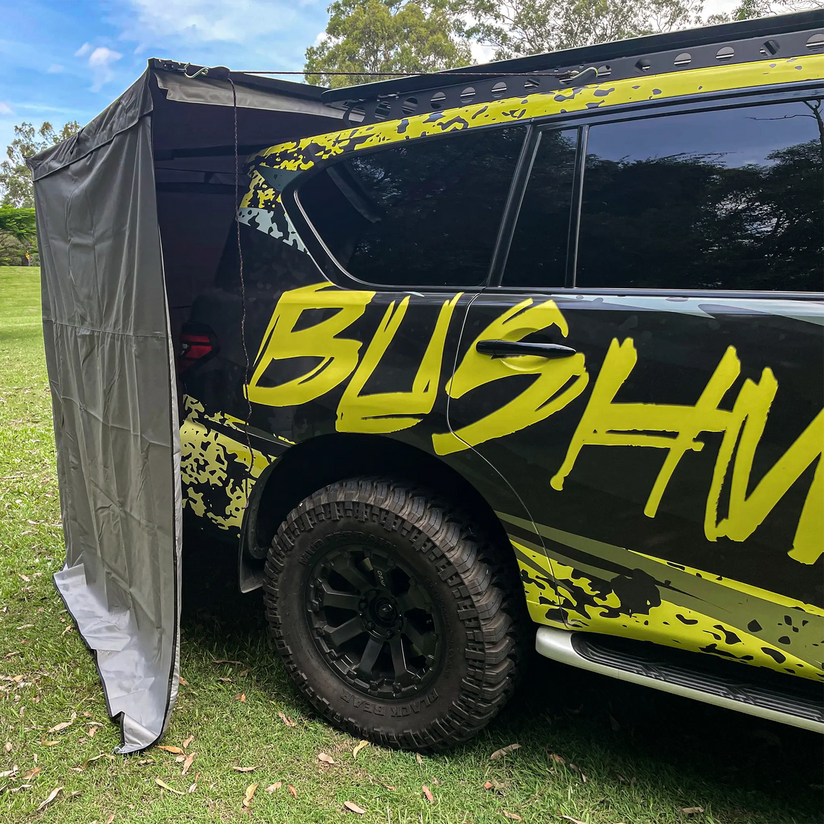 Bushwakka Extreme Darkness awning wall kit side close up with the wall edge beside the rear quarter of a Nissan Patrol.