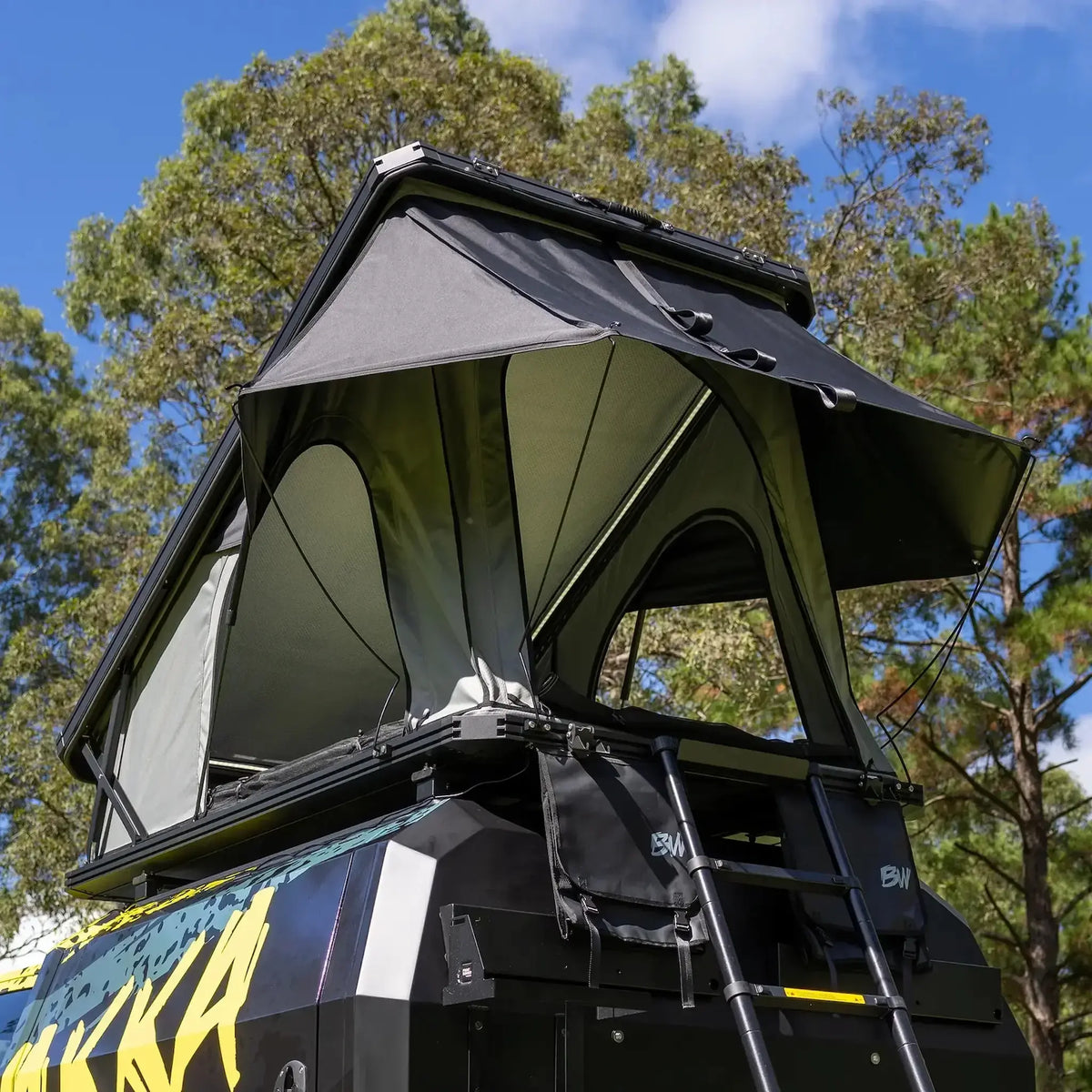 Bushwakka Stellar rooftop tent rear view with a ladder and rain fly held out by steel support poles.