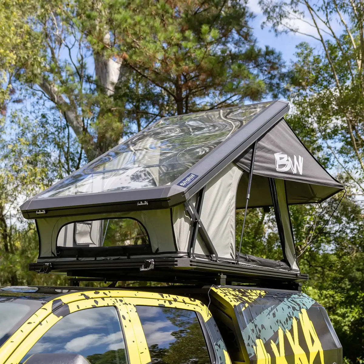 Bushwakka Stellar rooftop tent front view with the clear roof raised above the vehicle.