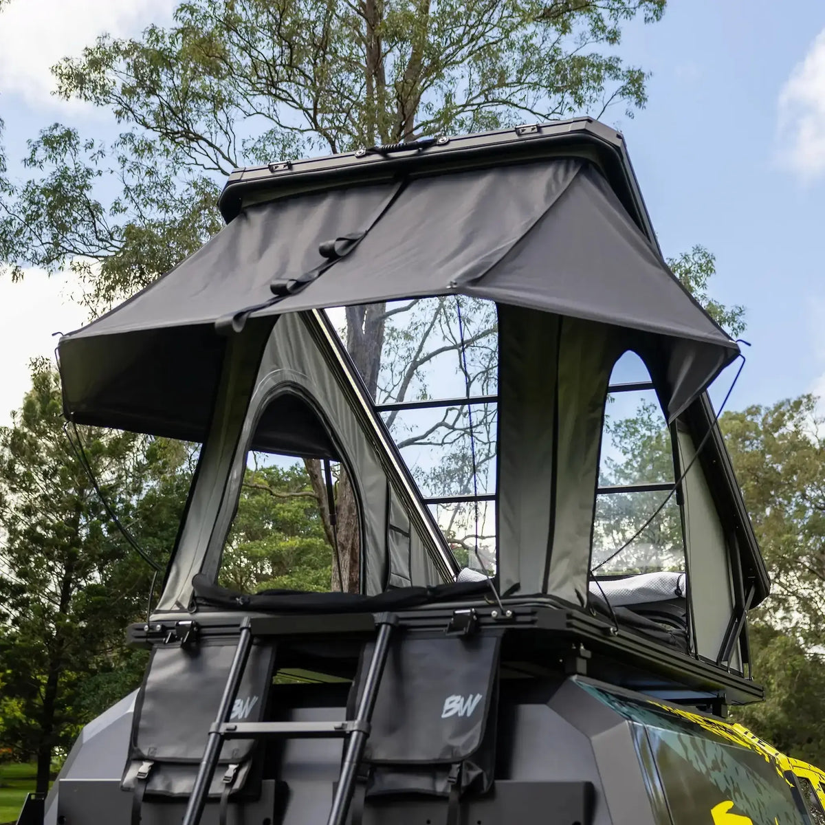 Bushwakka Stellar rooftop tent rear view with the rain fly extended above the entrance and ladder.