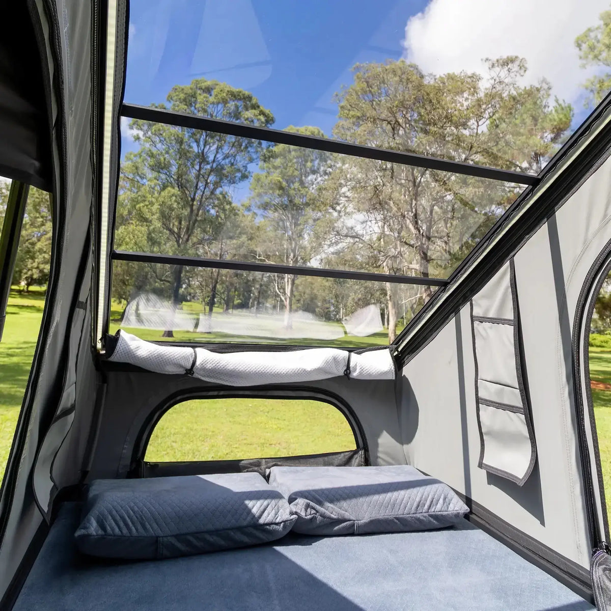 Bushwakka Stellar rooftop tent interior angled view of the clear roof above the pillows and front window.