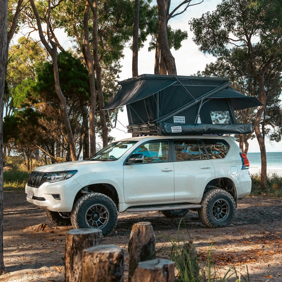 Outback Tourer 1250 Z Rooftop Tent side installed view on a white prado at camp.