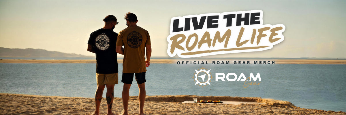 Live the Roam Life. Official Roam Gear merch. Two men on a beach at sunset wearing Roam Gear tees