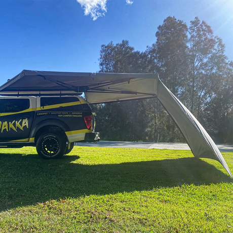 Bushwakka Extreme 180 degree awning wall installed side view beside a 4WD with the shaded area beneath visible.