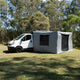 Bushwakka Extreme 270 awning wall kit installed beside a van with door and window panels open.