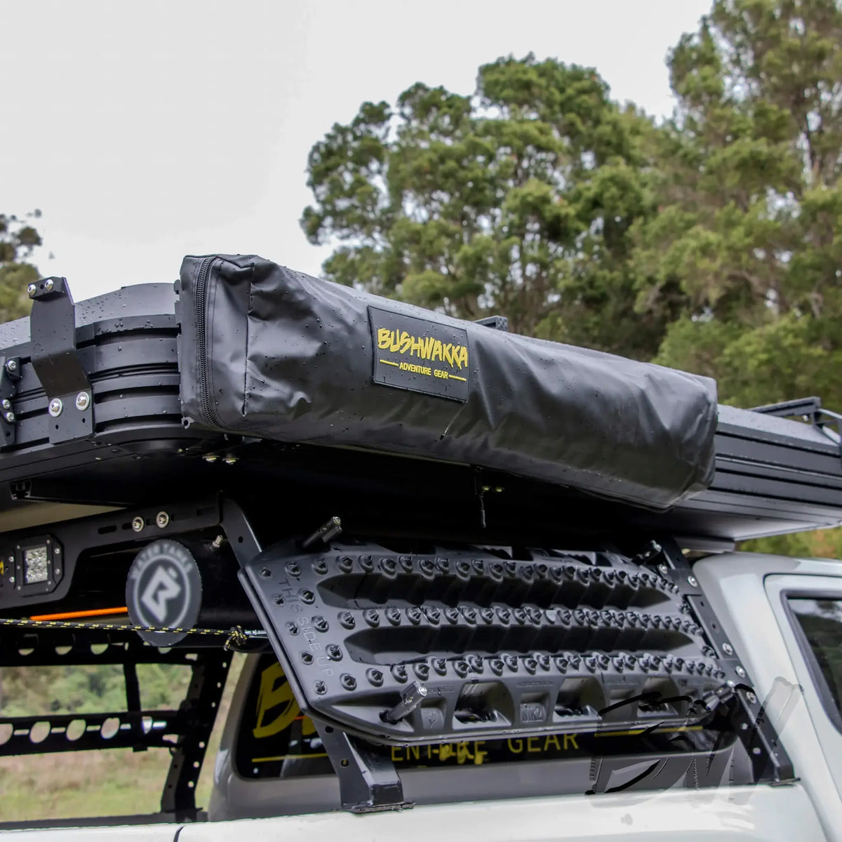 Bushwakka Extreme Shower Ensuite Single packed in its black travel cover on a vehicle roof rack.