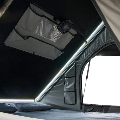 Bushwakka Nomad rooftop tent interior with hanging fan, storage pocket and side doorway.