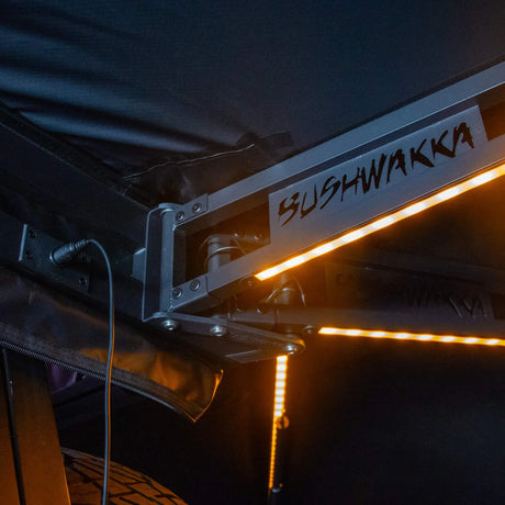 Bushwakka Passenger Side 270 Pro Awning light arm detail with orange LED strip under black canvas.