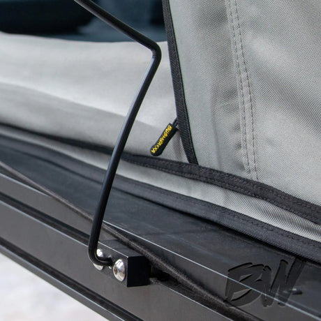 Bushwakka Shack rooftop tent rain fly steel pole close up at its mounting bracket on the base rail.
