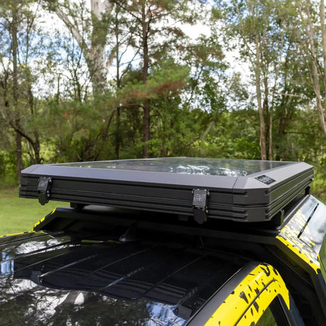 Bushwakka Stellar rooftop tent closed on a vehicle roof with two latches and a clear top panel.