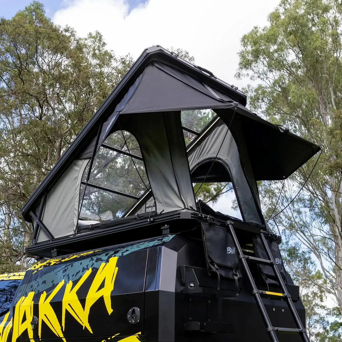 Bushwakka Stellar rooftop tent rear side view with the entrance open, ladder extended and clear roof above.