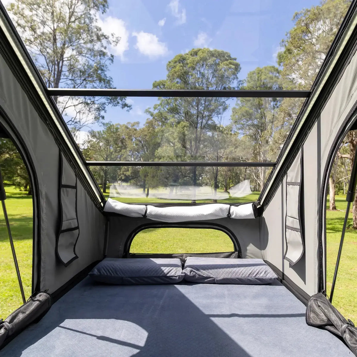 Bushwakka Stellar rooftop tent interior with a clear roof, mattress and pillows viewed through the entrance.