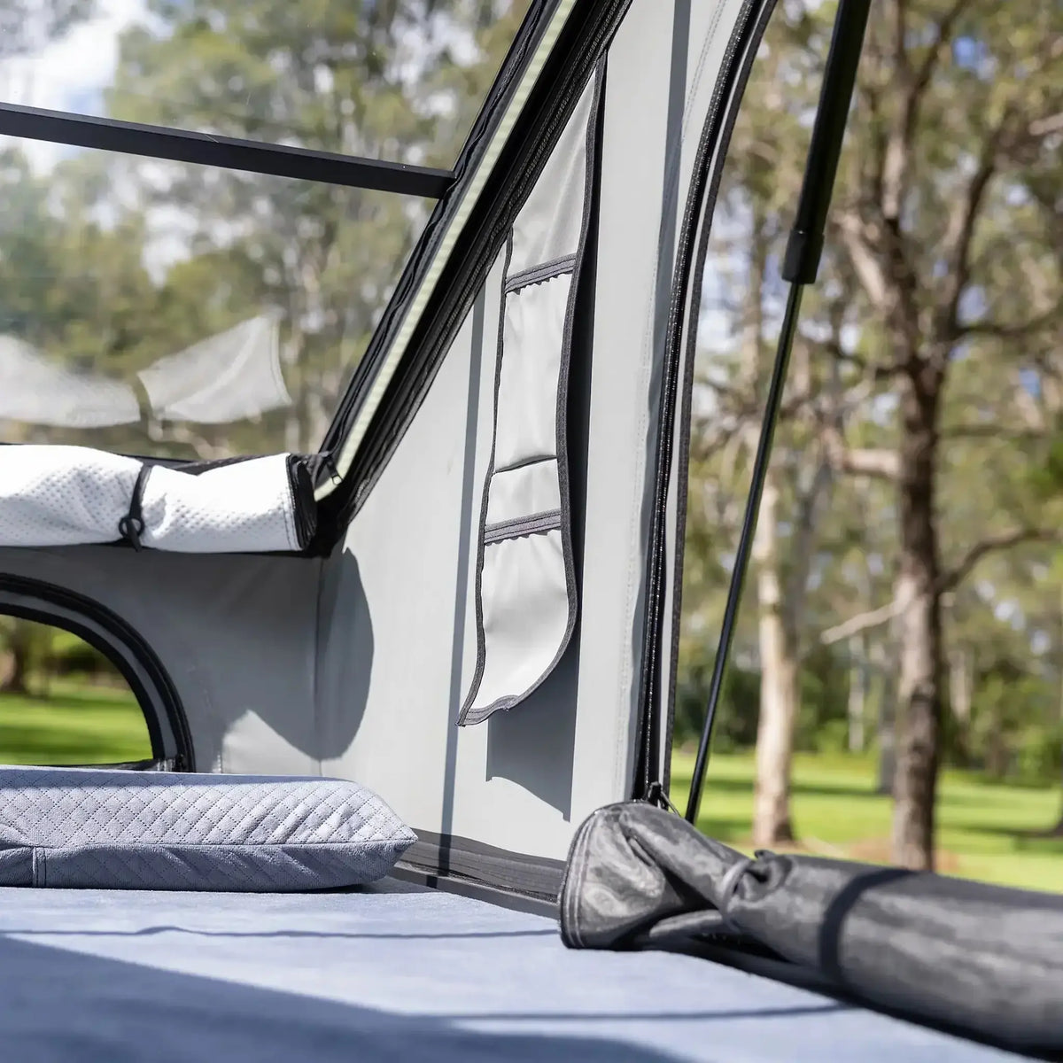 Bushwakka Stellar rooftop tent interior close up of storage pockets beside the mattress and side opening.