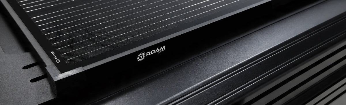 Roam Gear slimline solar panel mounted on a 4WD roof platform, close up of the black frame and Roam Gear logo