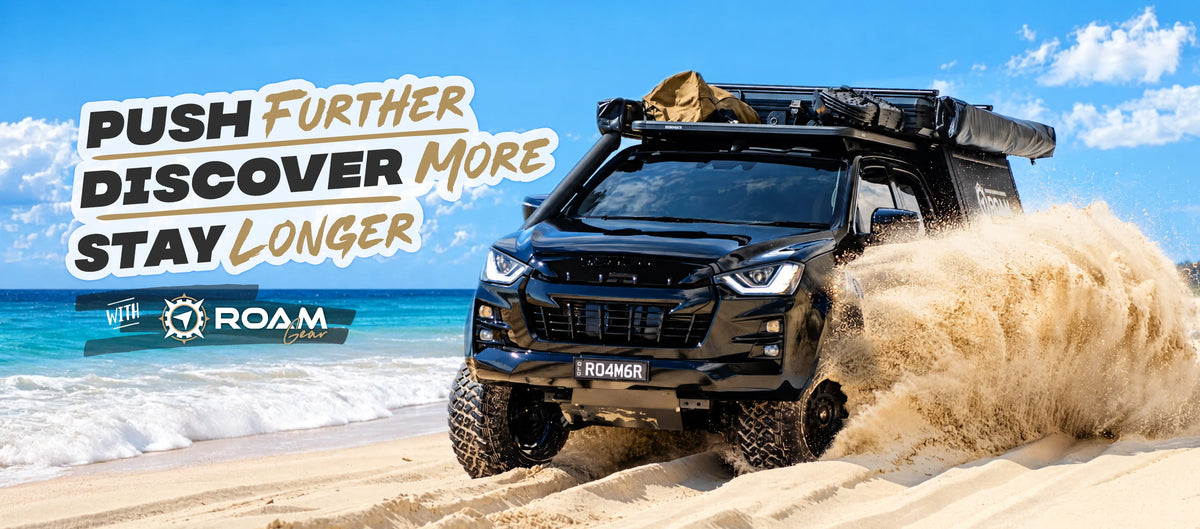 Push further, discover more, stay longer with Roam Gear. Black Isuzu D-Max kicking up sand on a beach