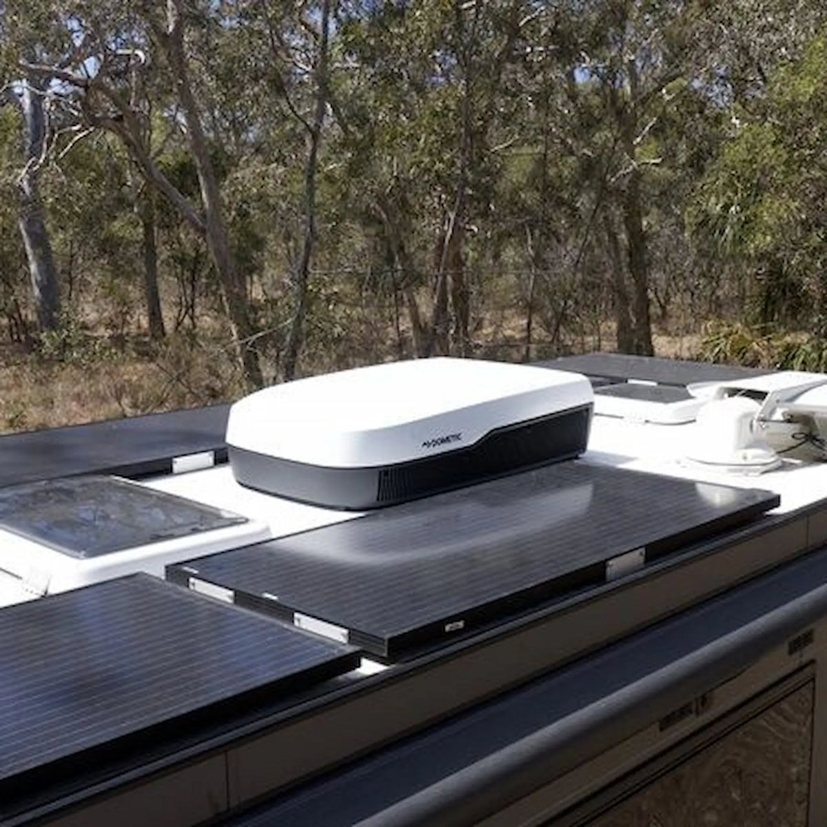 Dometic FreshJet 7 Series Plus white rooftop air conditioner installed on an caravan roof with solar panels.
