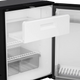 Dometic NRX 130 upright fridge interior view with freezer drawer pulled out and shelves.