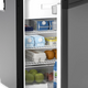Dometic NRX 50 upright fridge interior close up with eggs, milk, fruit and wire shelving.