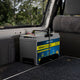 Hardkorr 100Ah lithium battery tray installed in a vehicle rear cargo area with the battery secured inside.