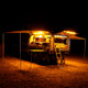 Hardkorr 100cm LED light bar kit casting orange light around a camper trailer and its awning at night.