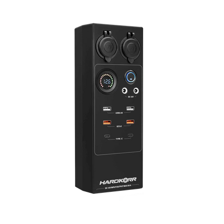 Large Hardkorr 12V DC power distribution box front view with covered sockets, a voltmeter and USB ports.