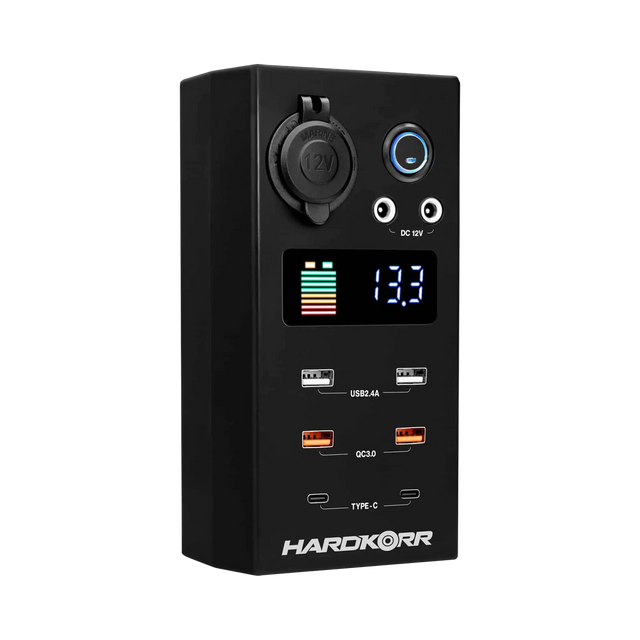Small Hardkorr 12V DC power distribution box front view with a battery level display, USB ports and covered socket.