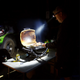 Hardkorr 145 lumen headtorch lighting a portable barbecue while a man cooks at night.