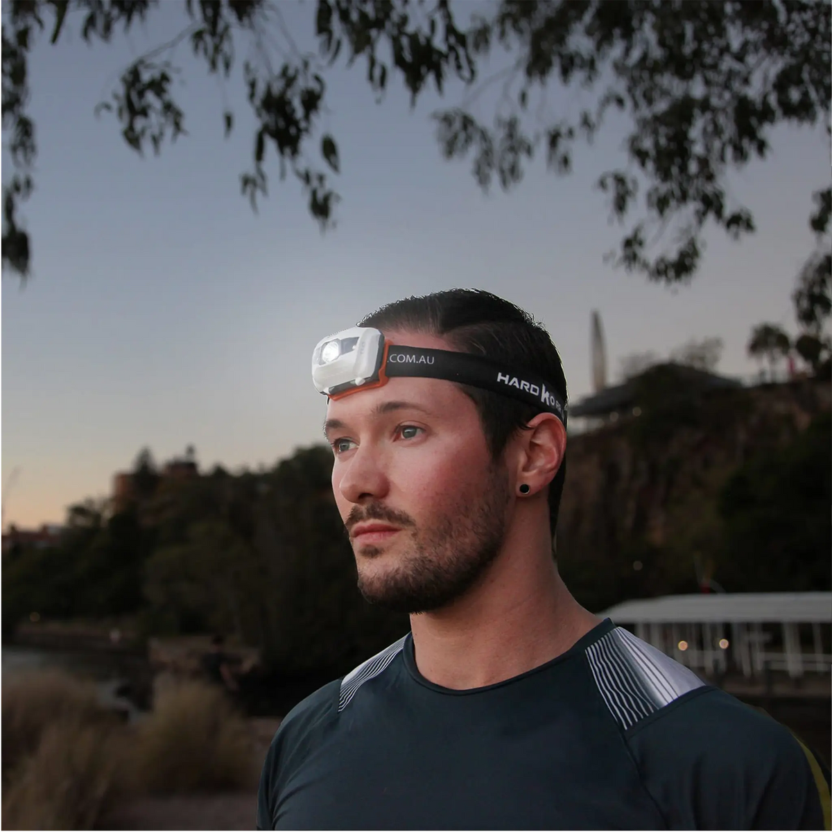 Hardkorr 145 lumen headtorch worn by a man outdoors at dusk with the light on.