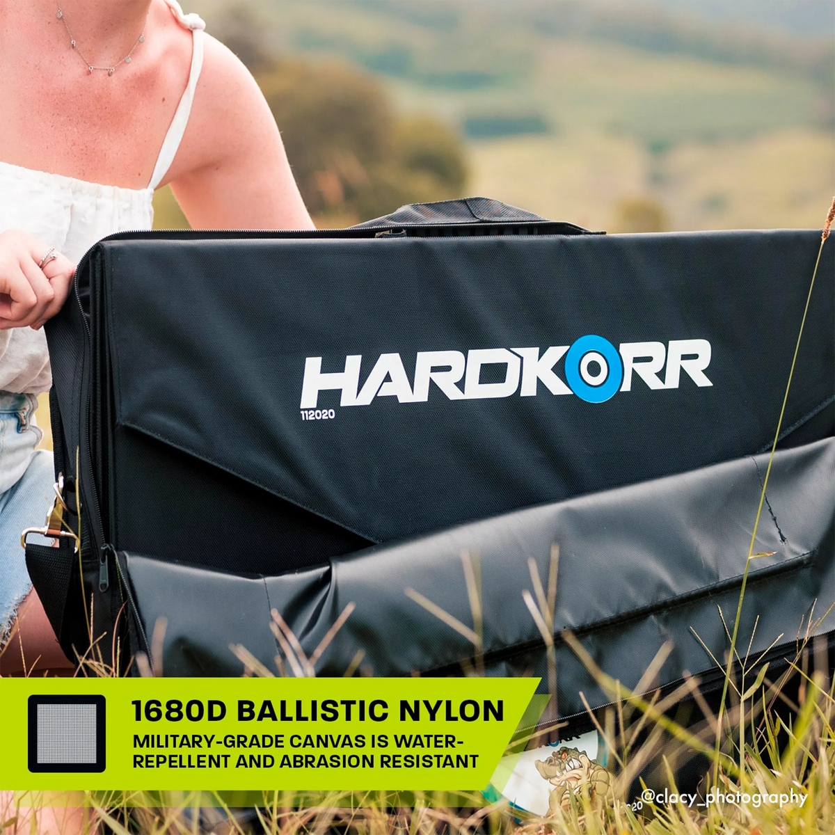 Hardkorr 150W 12V portable solar mat carry bag open in grass with the folded mat visible inside.