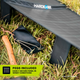 Hardkorr 150W 12V portable solar mat rear leg close up with a ground peg and hammer in grass.