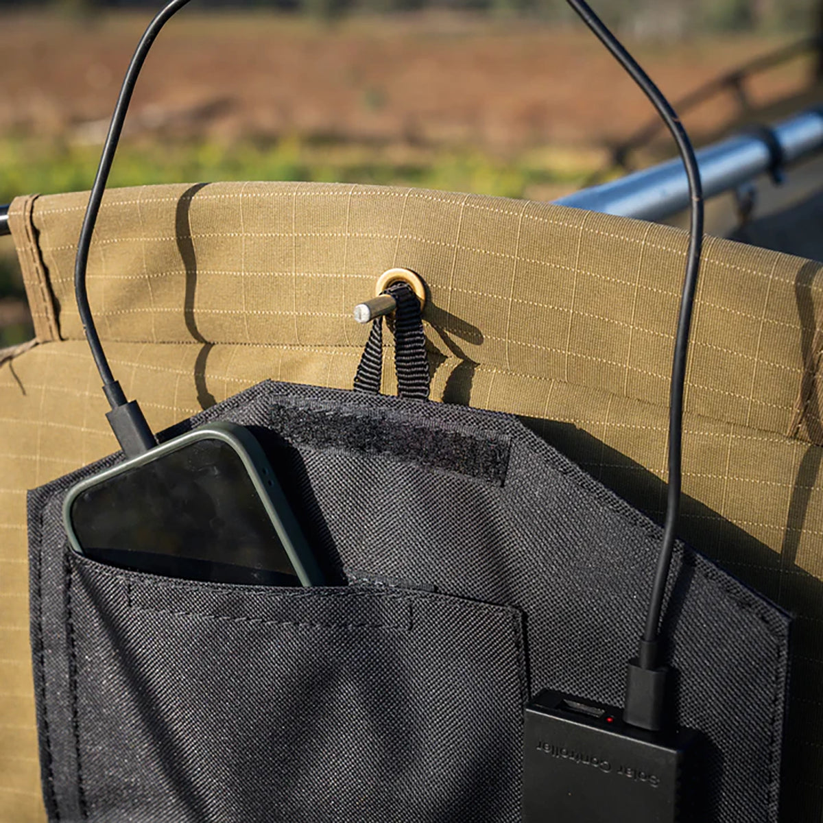 Hardkorr 15W dual USB solar device charger v2 pocket close up with a phone and USB cable connections.