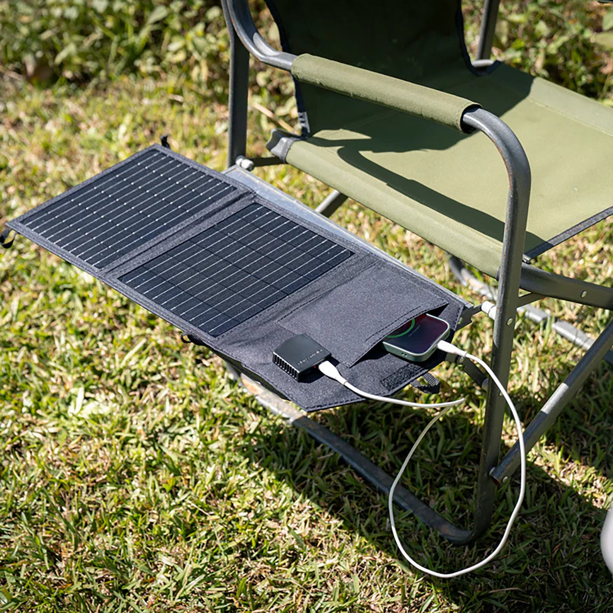 Hardkorr 15W dual USB solar device charger v2 spread across a camp chair with a phone connected by USB cable.