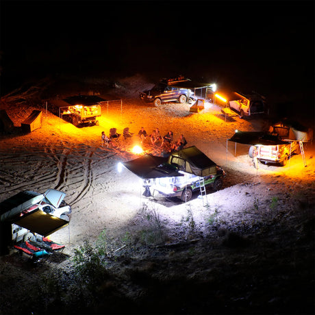 Hardkorr 2 bar LED camp light kit campsite view from above, with orange and white lights around vehicles.