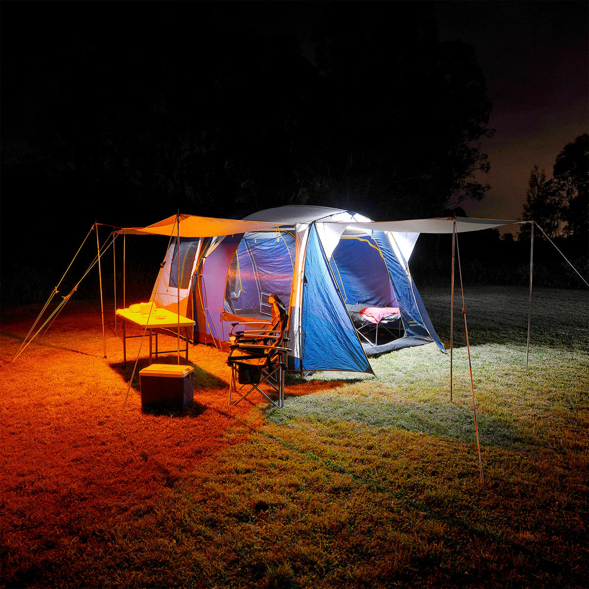 Hardkorr 2 bar LED camp light kit lighting a tent and its awnings in white and orange at night.