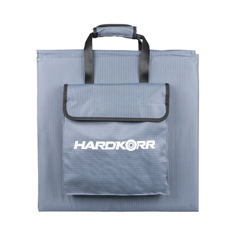 Hardkorr 200W 12V portable solar blanket folded into its grey carry bag with handles and a front storage pocket.