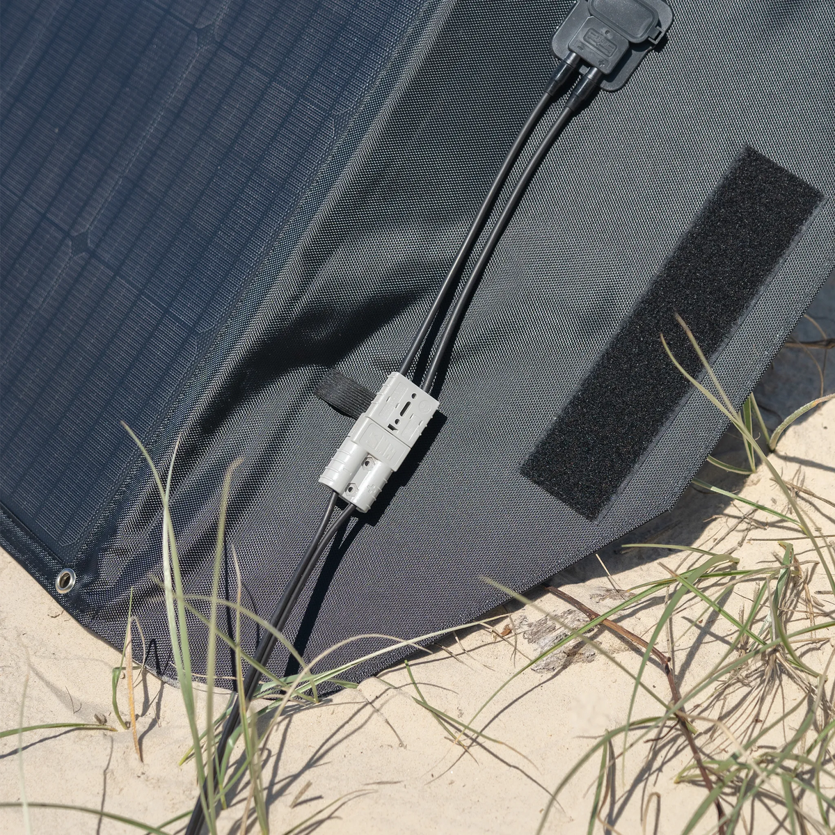 Hardkorr 200W 12V portable solar mat connector close up with an Anderson plug and paired leads on the end flap.