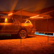 Hardkorr 3 strip LED awning light kit casting orange light beneath a vehicle awning at night.