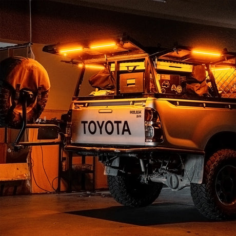 Hardkorr 50cm LED light bars casting orange light over a ute tray beneath an awning.