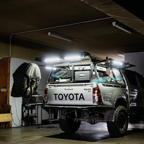 Hardkorr 50cm LED light bars casting white light over a ute tray and the floor beneath an awning.