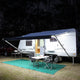 Hardkorr 5m white flexible LED tape light illuminating a caravan awning and camping table at night.