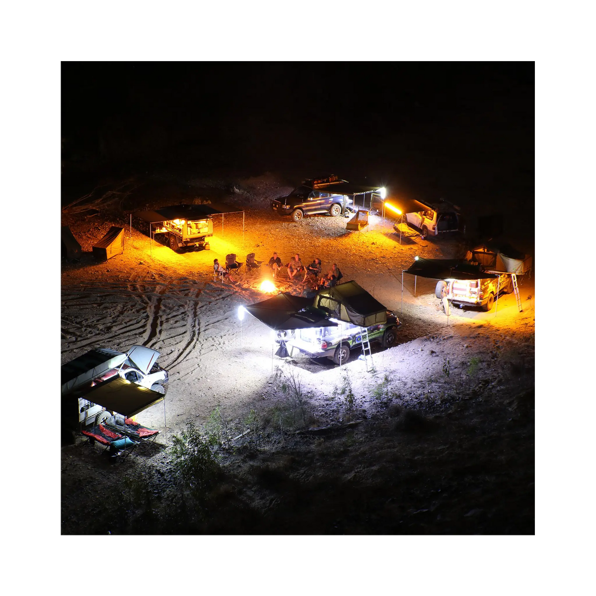 Hardkorr 6 bar LED camp light kit campsite view from above, with orange and white lights around vehicles.