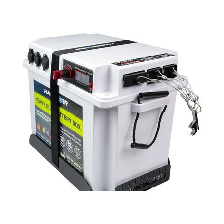 Hardkorr Anderson plug covers fitted to the side ports of a white battery box with their wire lanyards hanging.
