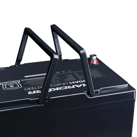Hardkorr Black 100Ah 12V lithium battery close up of raised carry handles and positive terminal.