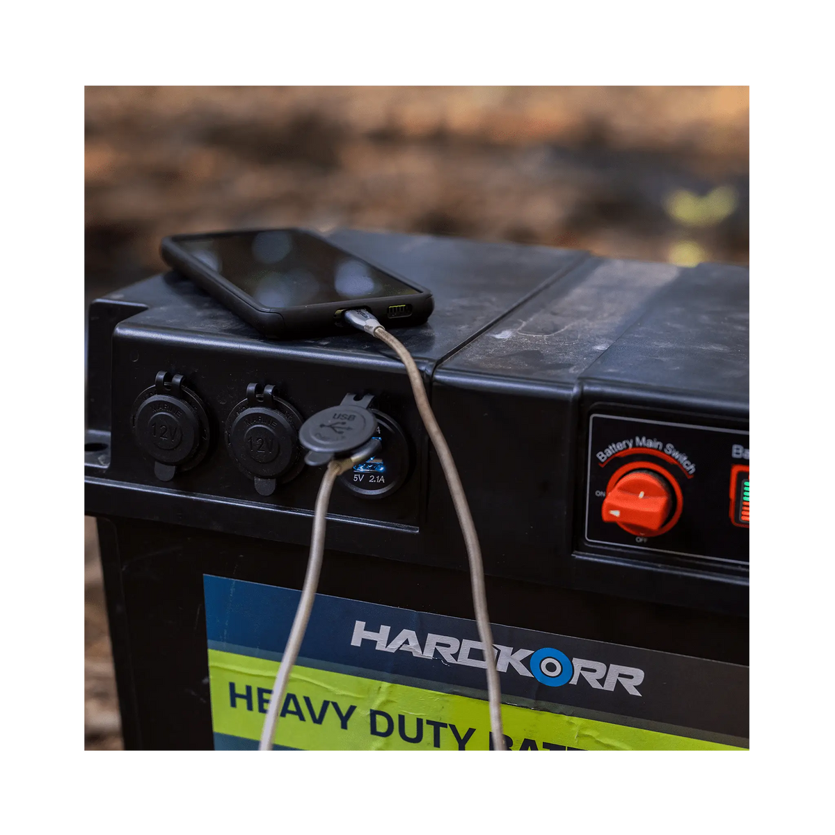 Black Hardkorr battery box USB socket close up with a phone connected on the lid.
