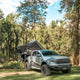Outback Tourer 1.5 Pro Rooftop Tent open side view on a grey ute in a forest campsite.