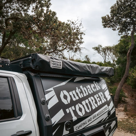 Outback Tourer 180 Awning packed in its black travel bag mounted on a vehicle.