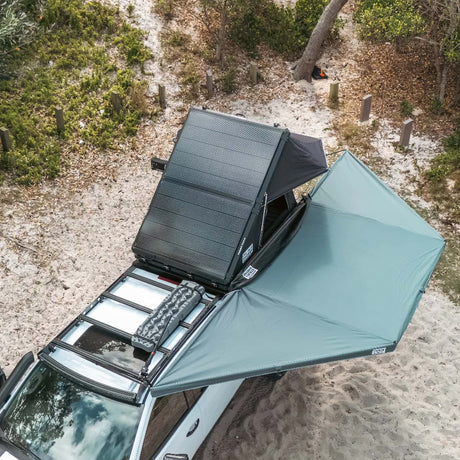 Outback Tourer 180 Awning overhead view open beside a vehicle with a rooftop tent open.