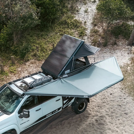 Outback Tourer 180 Awning side overhead view open beside a white vehicle.