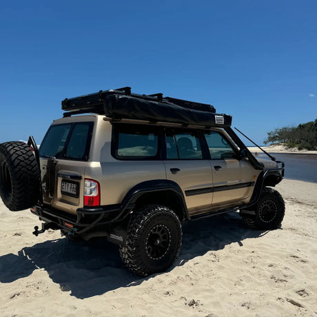 Outback Tourer Drivers Side 270 Awning packed down which is mounted on a roof rack at the beach.