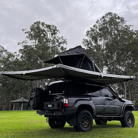 Outback Tourer Drivers Side 270 Awning back left view with rooftop tent on a grass campsite.